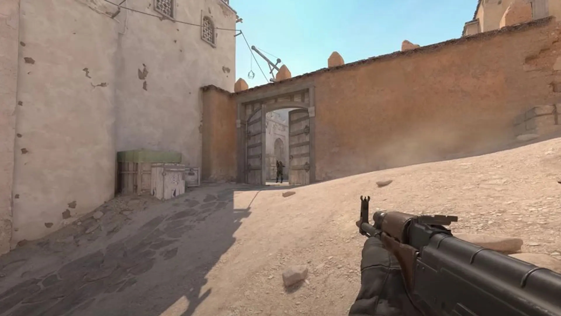 Counter Strike 2 patch notes: A player wielding an AK47 approaching a door on Dust 2