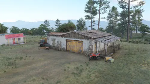 A barn with trees in the background.