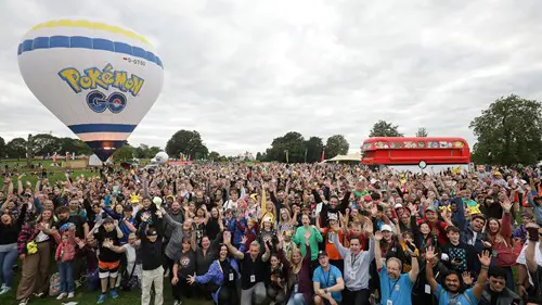 Many fans in front of the Pokemon GO Balloon and Pokemon Bus