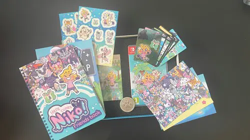 Everything included in Super Rare Games' Here Comes Niko! Collector's Edition - a Friends Book, a Train Map, sticker sheets, a real metal Friend Token, a CD copy of the game's soundtrack, the game box, some trading cards and some postcards, all housed in the special edition box.