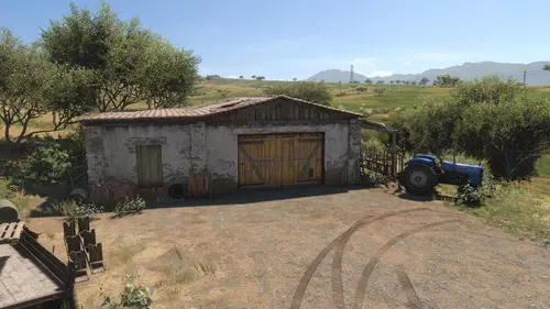 A barn with rolling hills in the background.